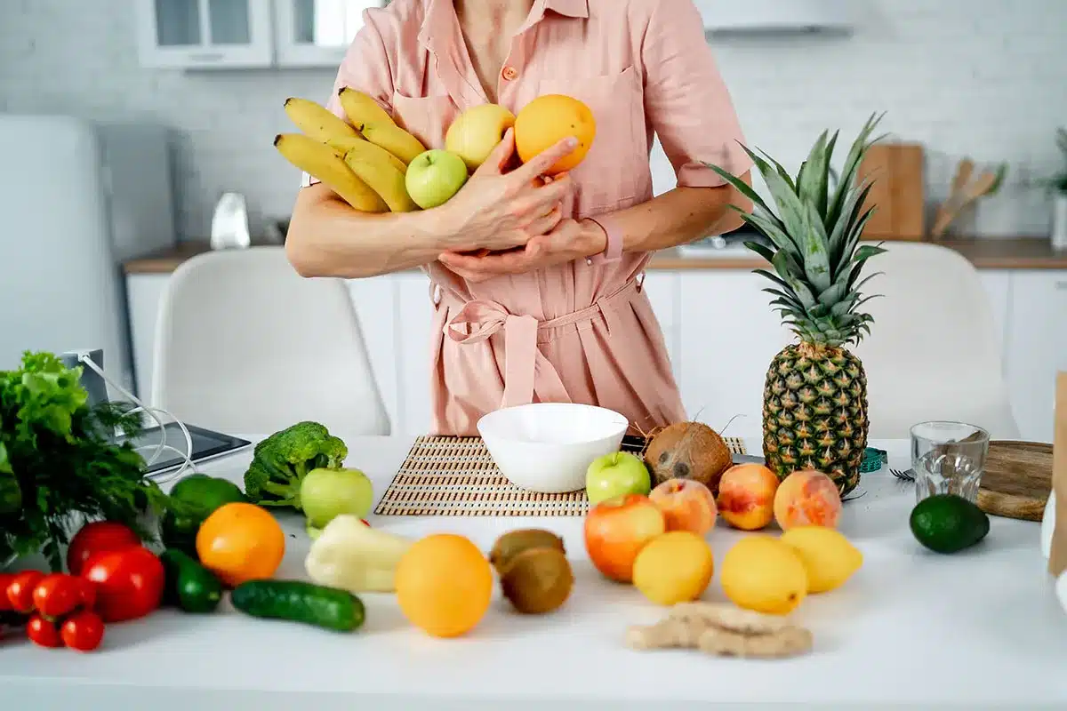 Woman holding bowl of fresh fruit.