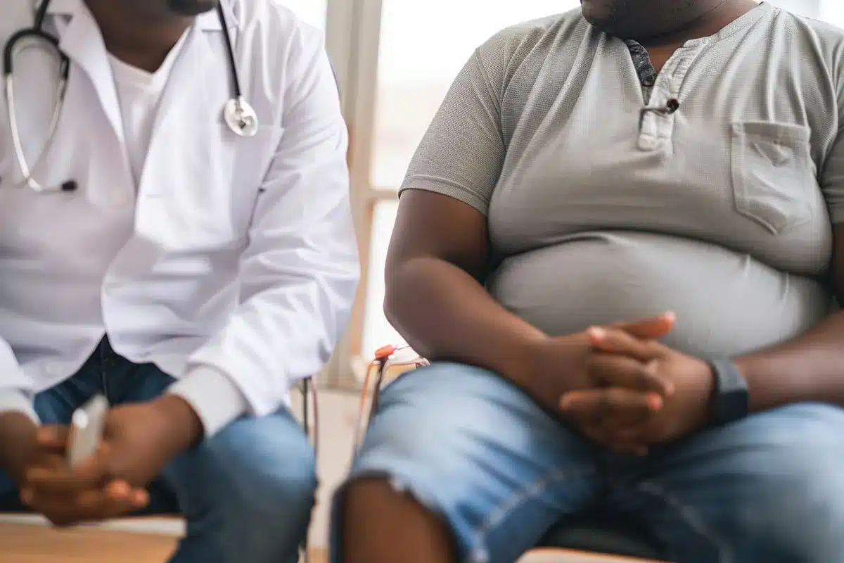 Doctor and overweight patient sitting.