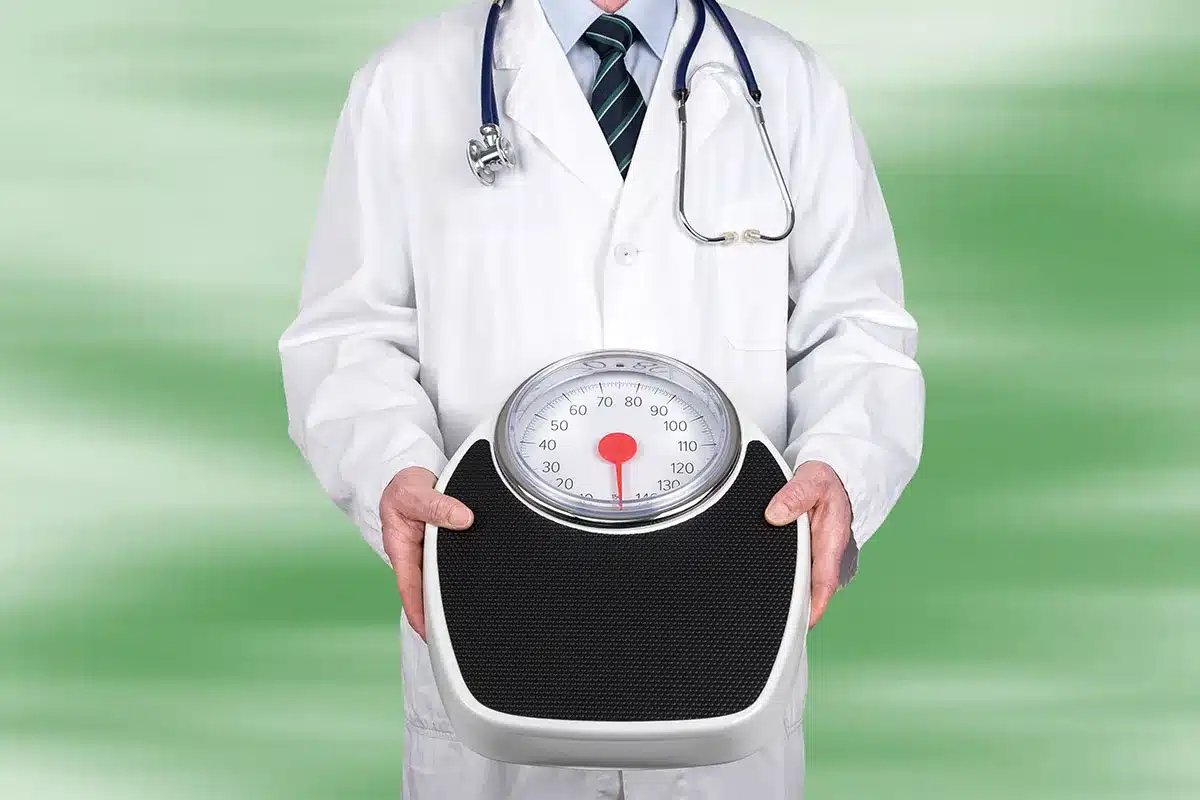 Doctor holding a weight scale.