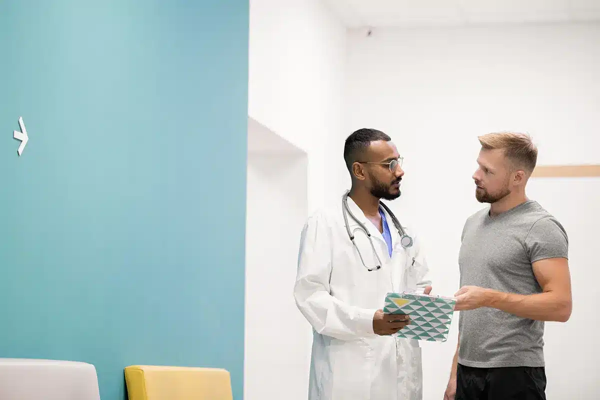 Doctor and patient talking in hallway.