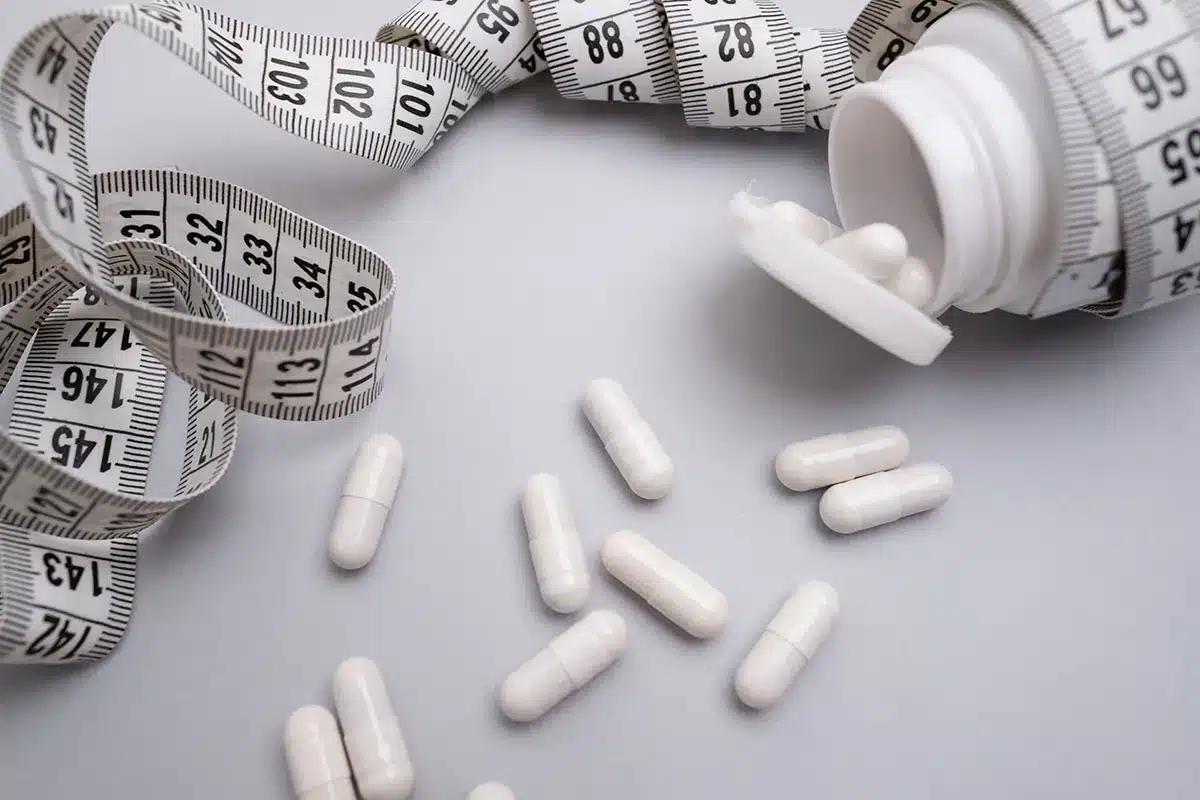 Weight loss pills and measuring tape.