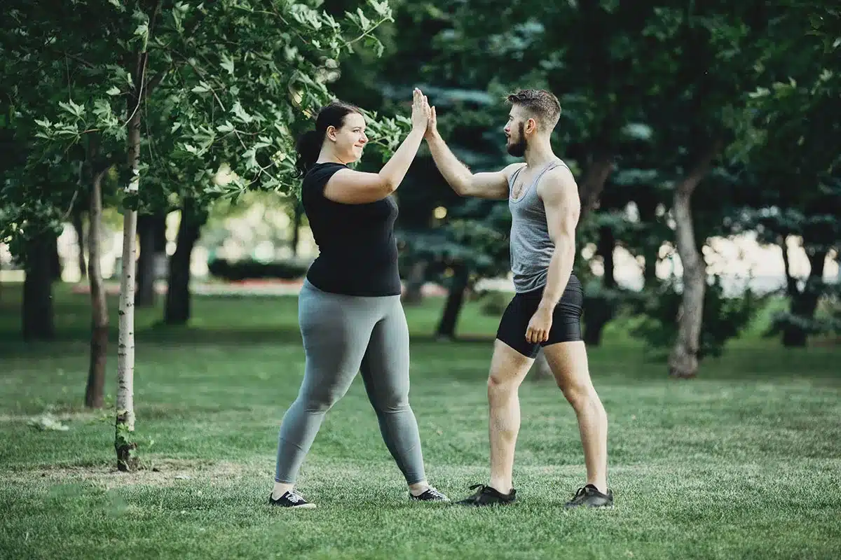 Plus-size woman and man high-fiving.