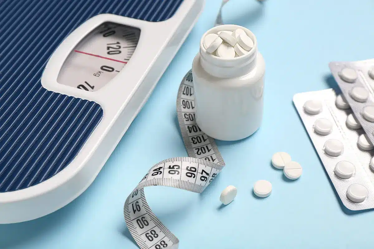 Weight scale, pills, and measuring tape.