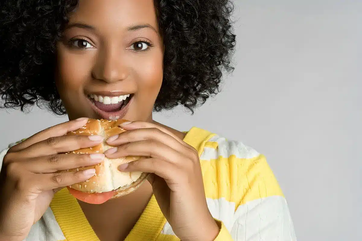 Happy woman enjoying a burger.