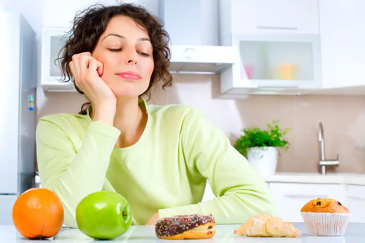 Woman deciding between healthy and unhealthy snacks.
