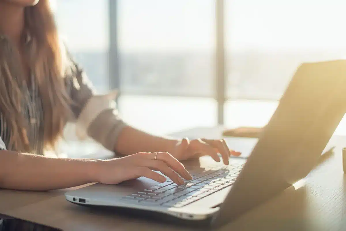 Woman's hands typing on a laptop.