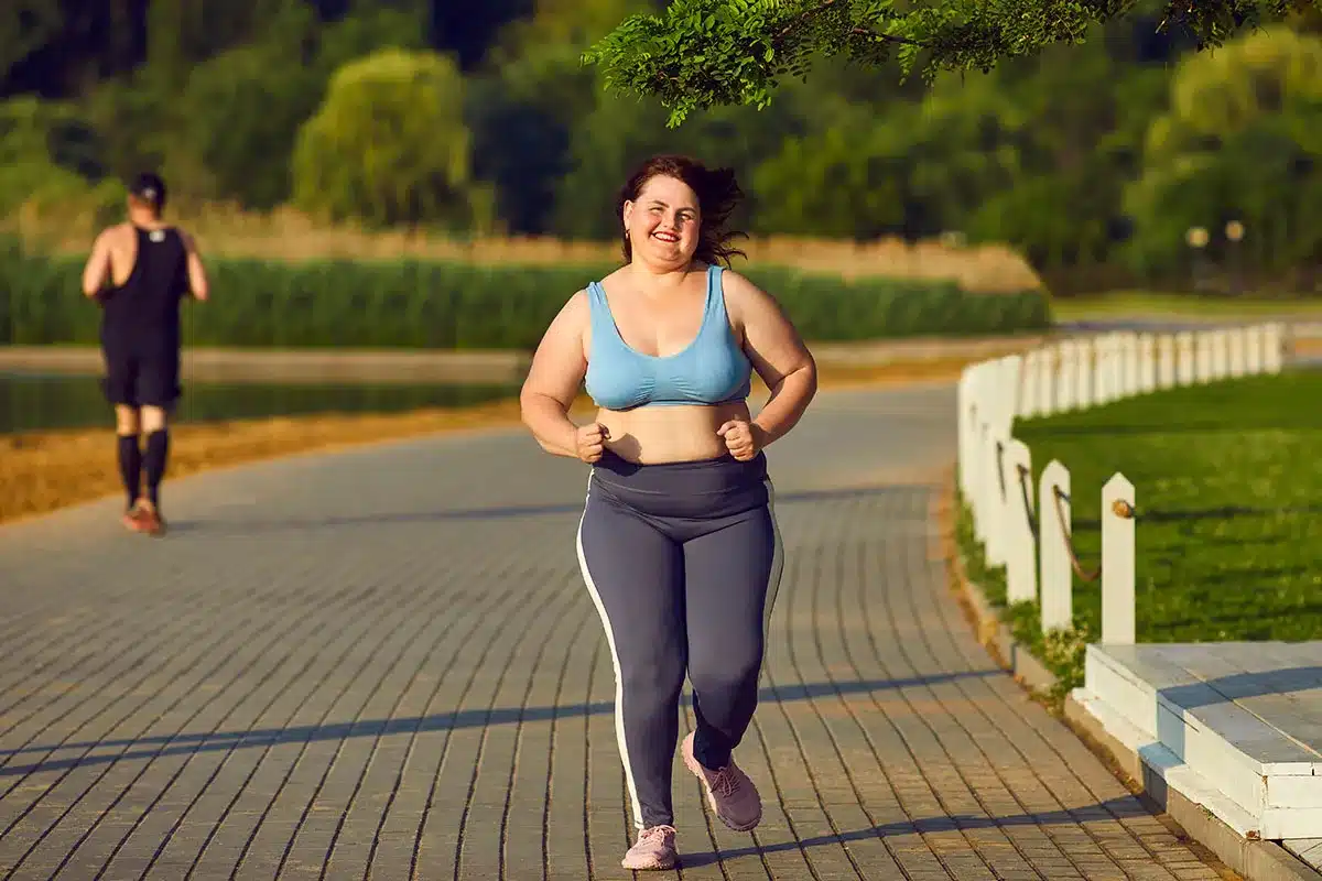 Plus-size woman jogging outdoors.