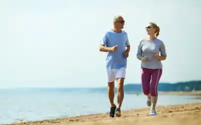 Senior couple jogging on the beach.