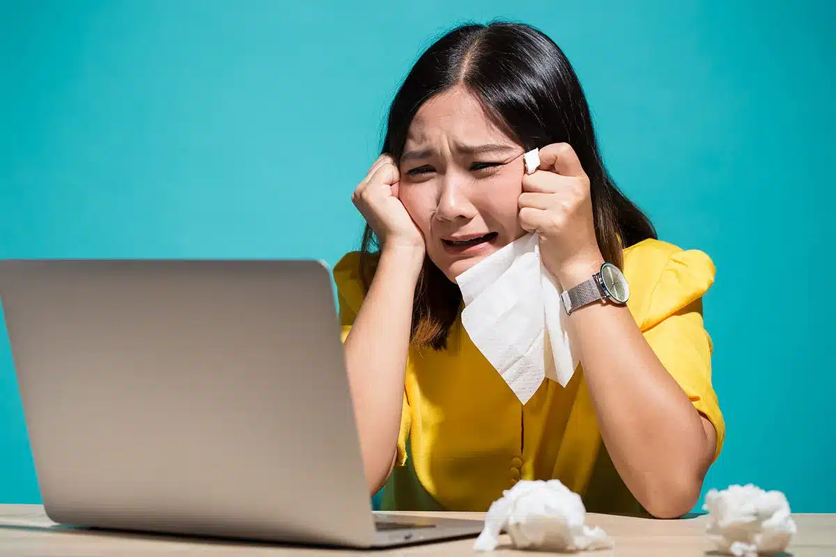 Woman crying at her laptop.
