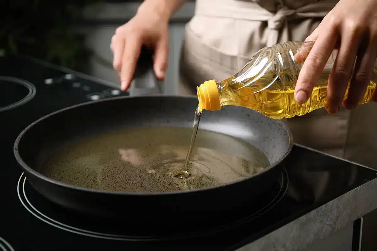 Pouring oil into a frying pan.