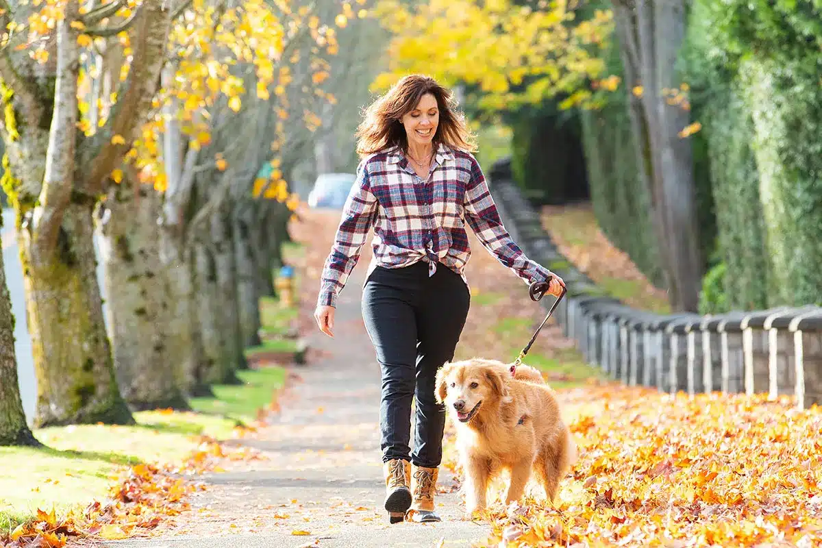 Woman walking her golden retriever.