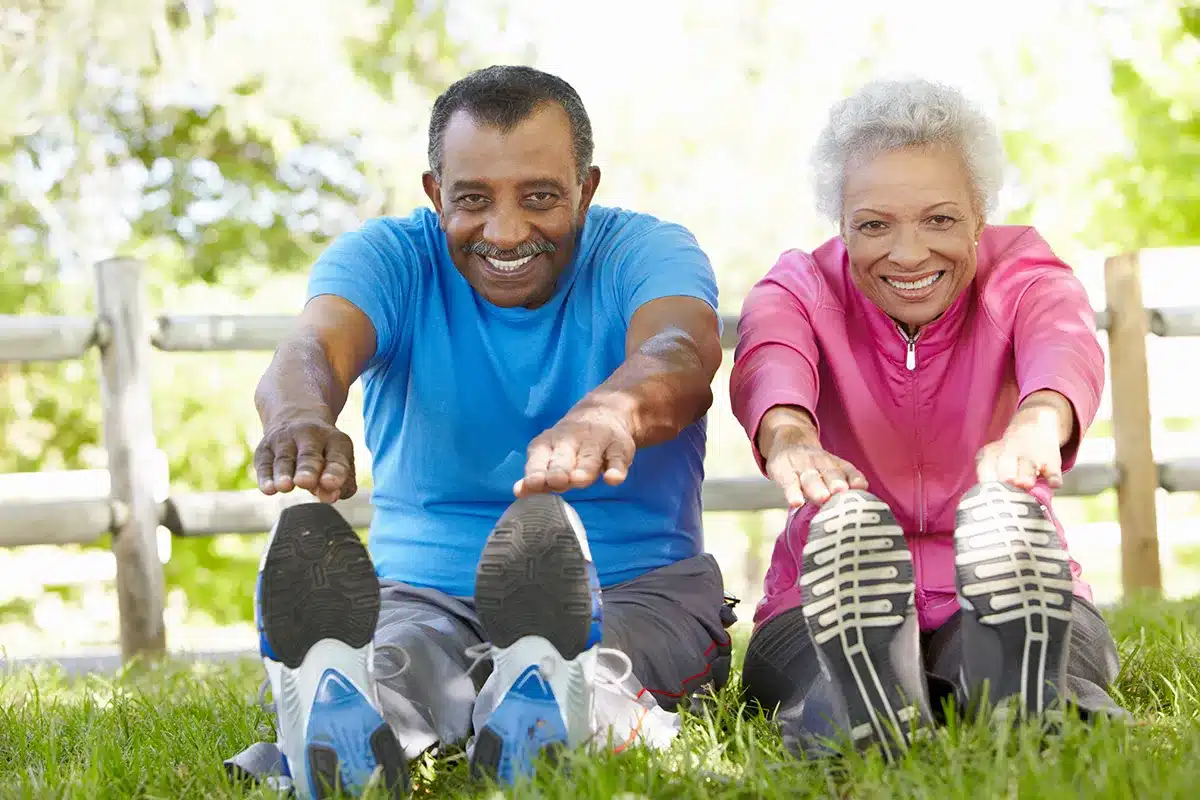 Senior couple stretching in park.