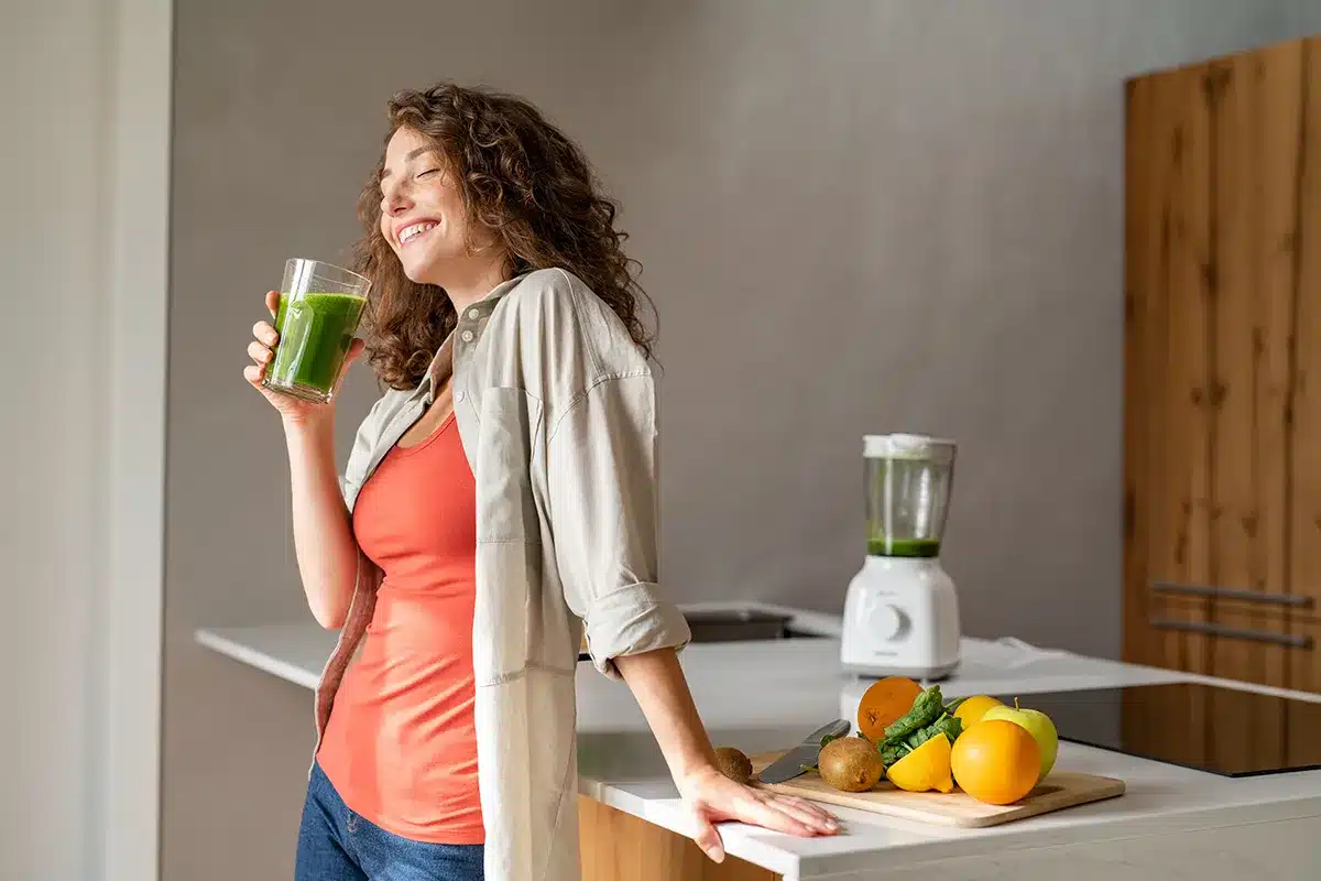 Woman enjoying green smoothie.