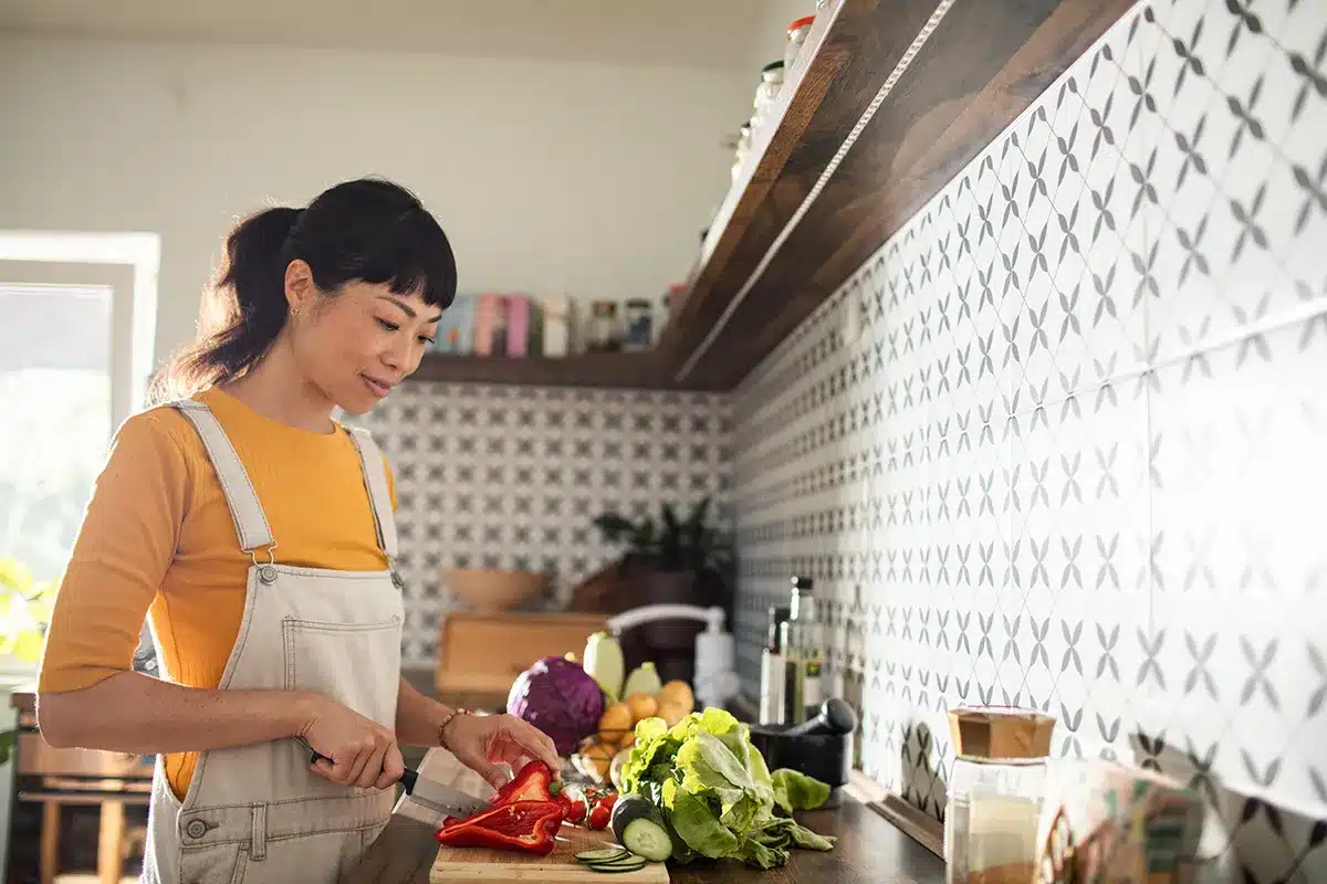 Woman preparing vegetables in kitchen.