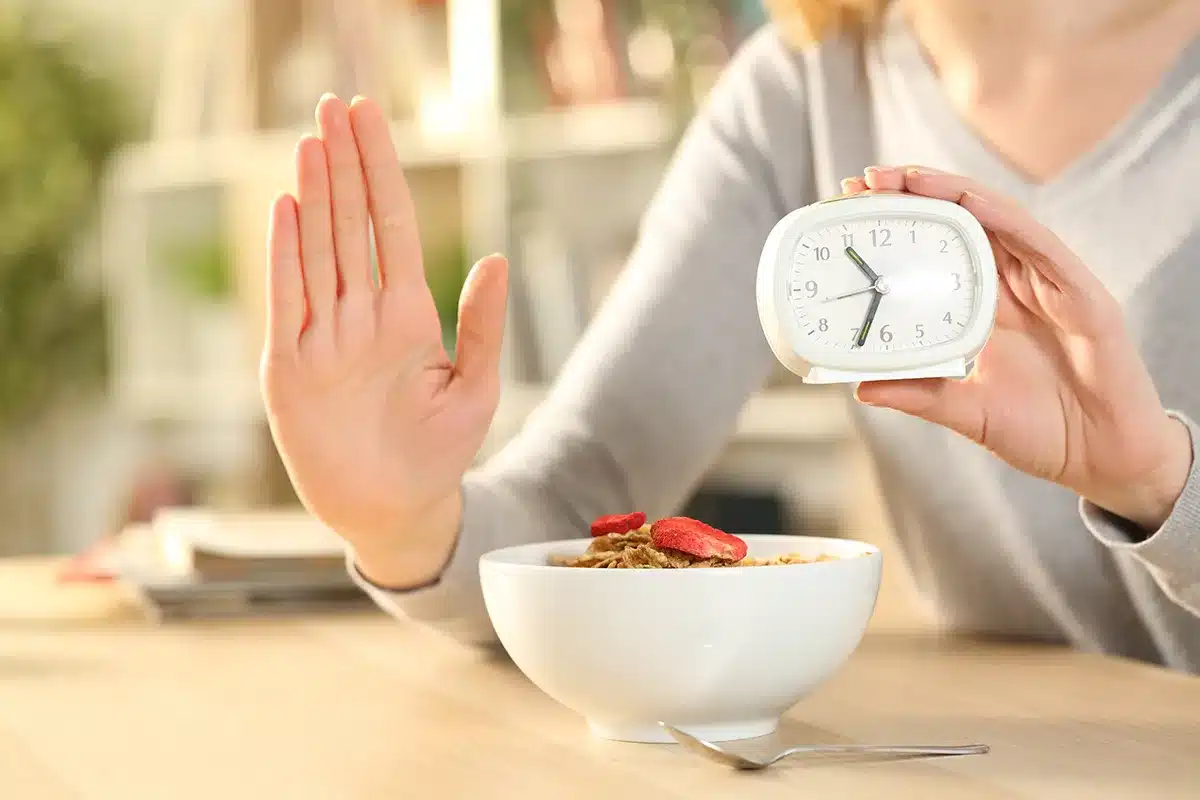 Woman refusing breakfast, holding clock.