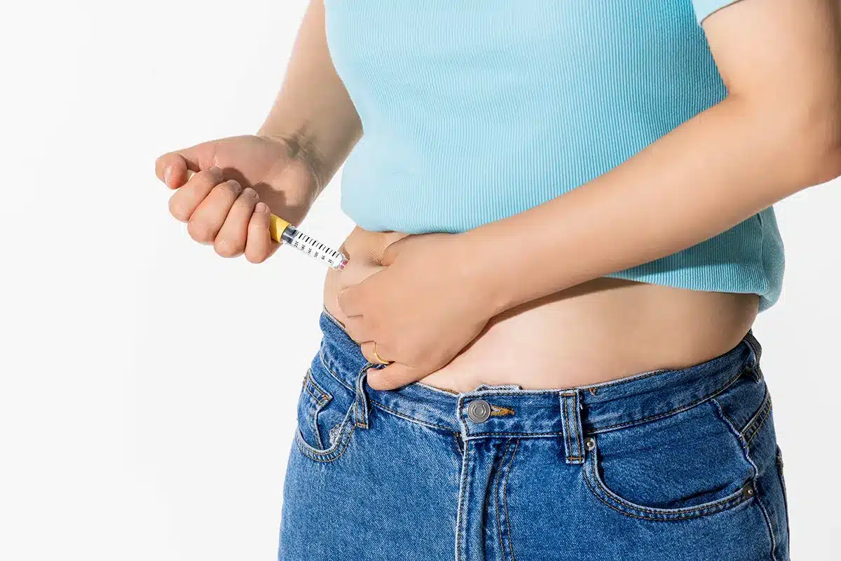 a woman injecting herself with obesity medication