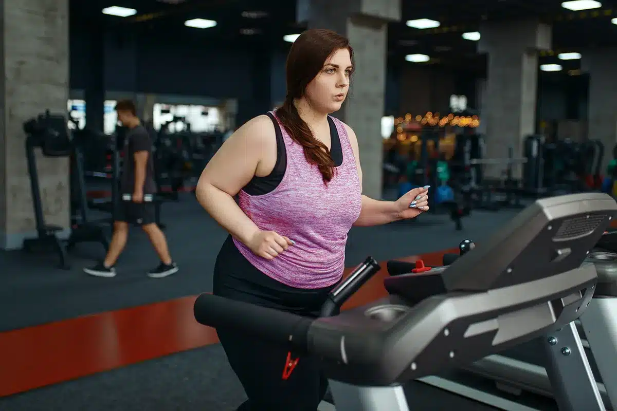 Plus-size woman exercising on treadmill.