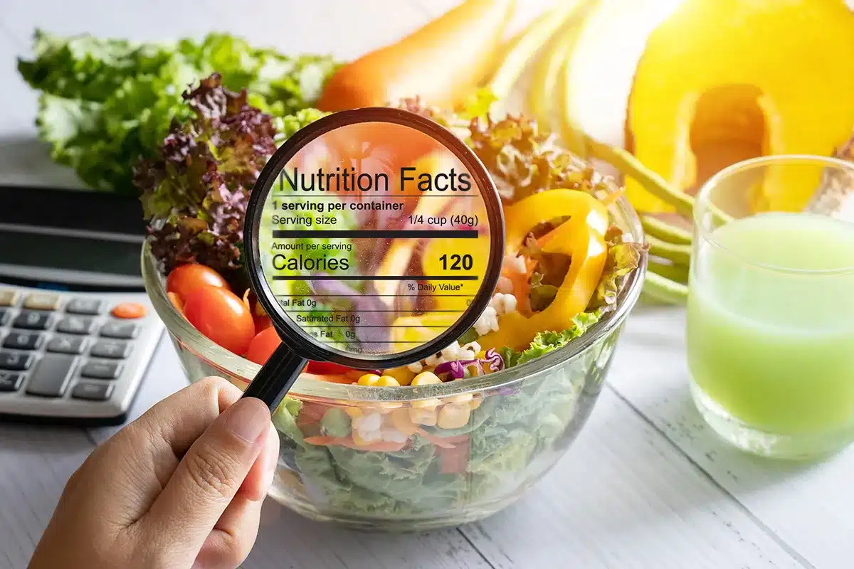 A magnifying glass focuses on the nutrition facts of a healthy salad.