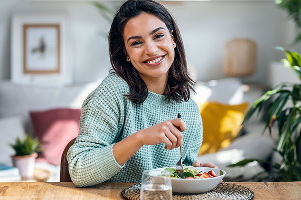 Beautiful smiling woman eating healthy meal