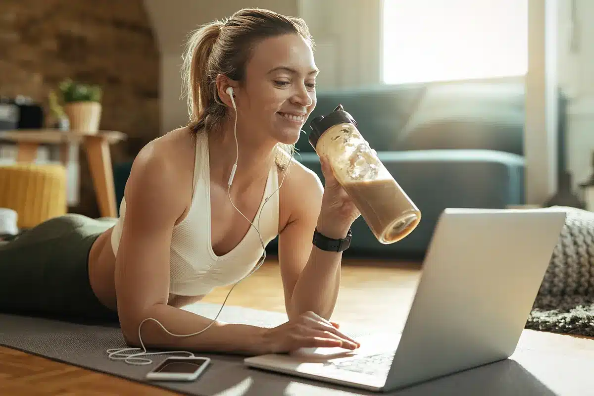 happy athletic woman drinking protein shake