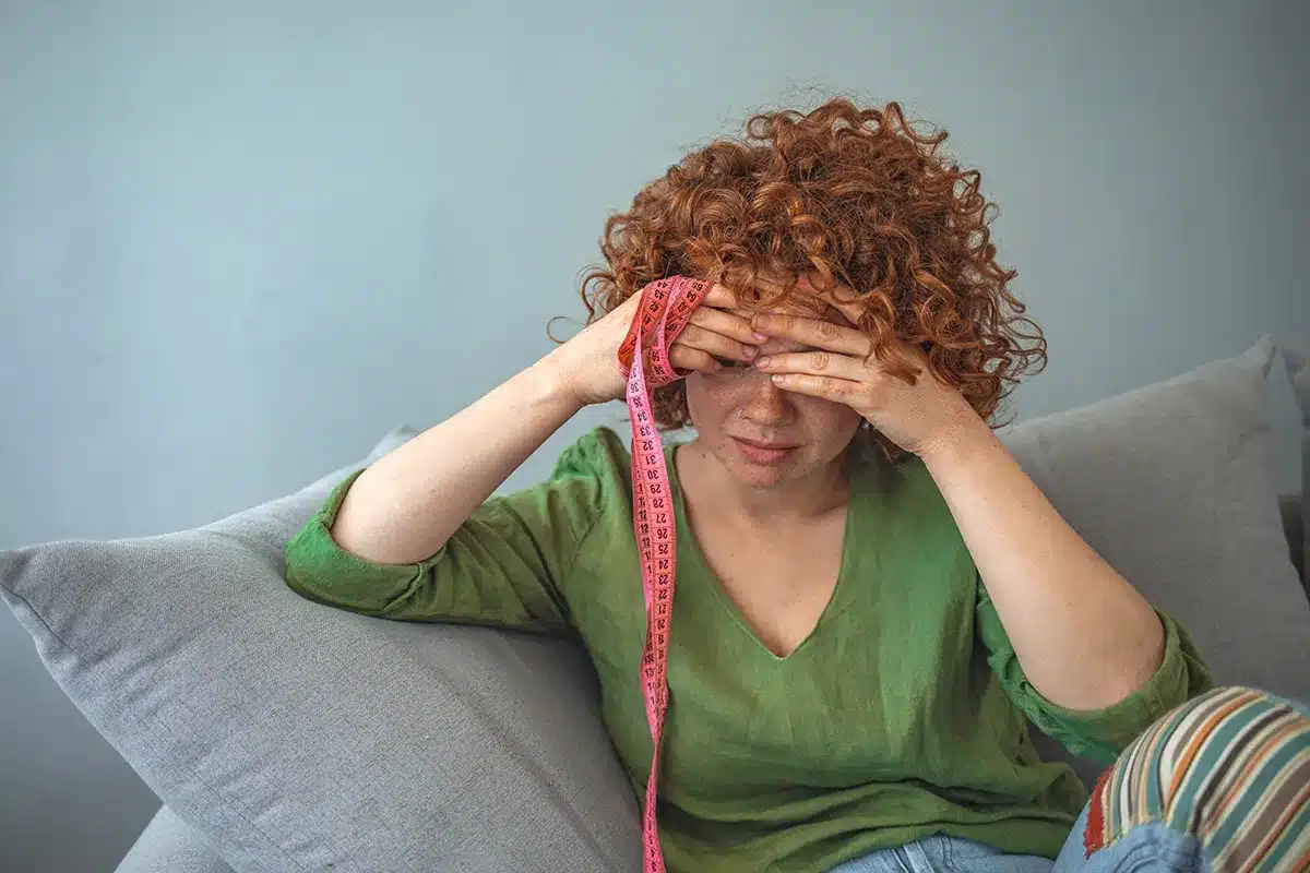 Woman feeling stressed about body image.