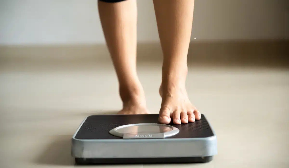 A person stepping onto a weight scale, representing weight management and healthy choices.