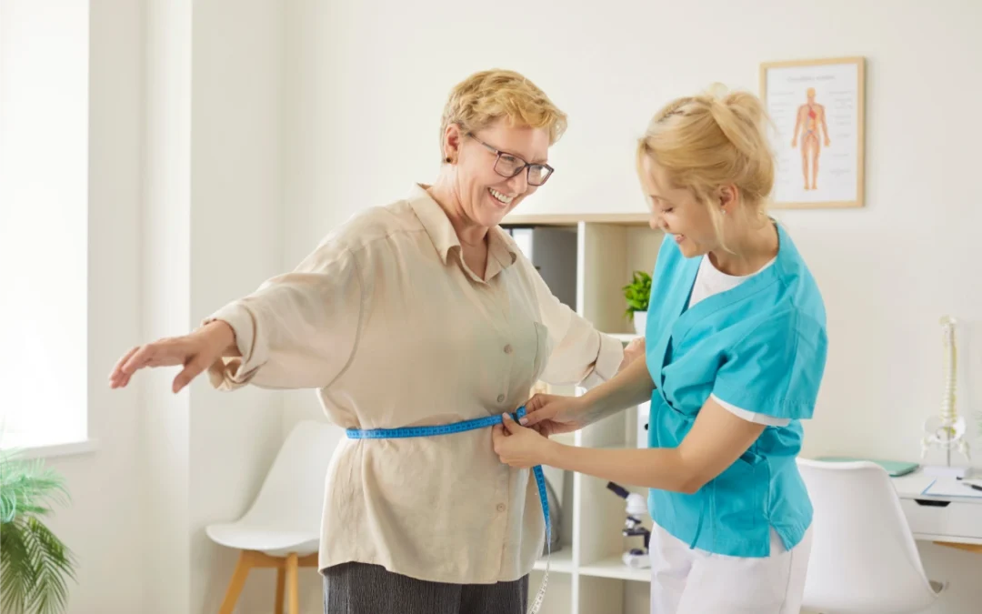 nurse measuring waist of smiling senior woman with tape